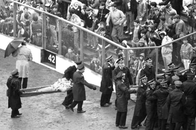 Ambulance volunteers and police move in when crowd trouble starts during the 1985 game