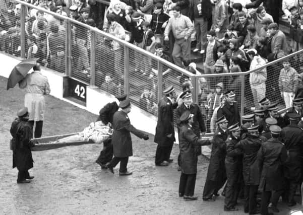 Ambulance volunteers and police move in when crowd trouble starts during the 1985 game