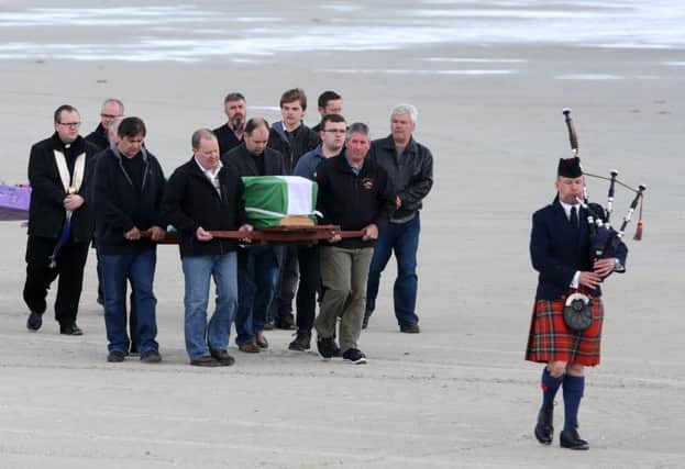 The coffin of Eilidh MacLeod draped in the Barra flag is carried across Traigh Mhor beach at Barra airport after it arrived by chartered plane. Picture: Andrew Milligan/PA Wire