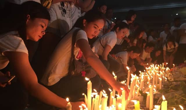 Mourners in the Philippine capital, Manila, light candles and lay flowers in front of a memorial outside the Resorts World Manila entertainment complex. Picture: AP Photo/Todd Pitman