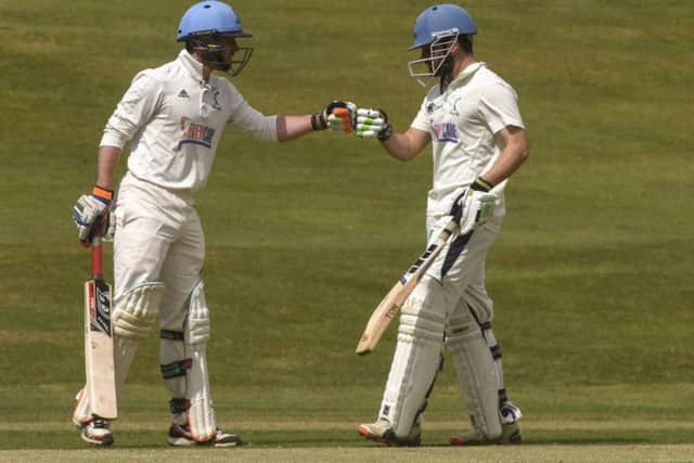 Carlton batsman Ali Shah, right, celebrates his 50 with Fraser Boyd as the champions enjoyed a 116-run victory over Heriot's. Picture: Andrew O'Brien