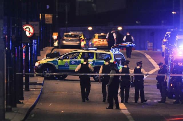 Police officers walk at the scene of the terror attack on London Bridge. Picture: DANIEL SORABJI/AFP/Getty Images