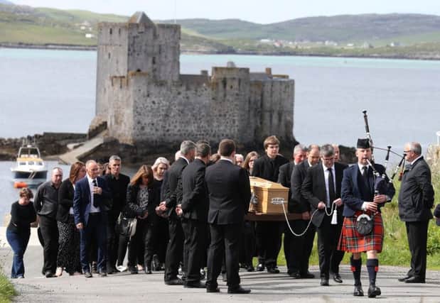 Roddy MacLeod father of Manchester bomb victim Eilidh MacLeod leads the funeral procession as it passes Kisimul Castle on its way to the Church of Our Lady, Star of the Sea, in Castlebay on the island of Barra.