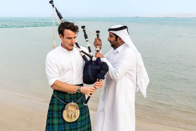 Picture: Ross getting assistance from a member of the Qatari pipe band, contributed