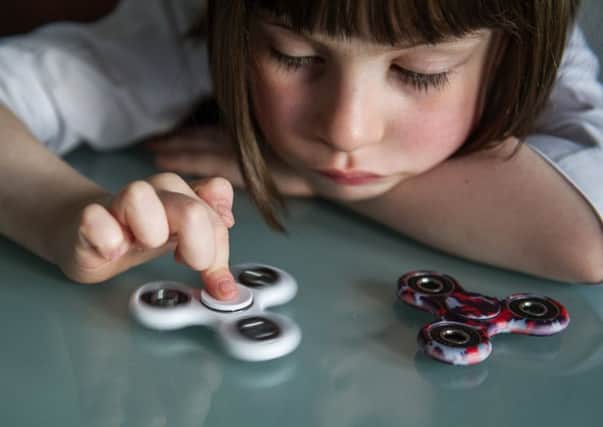 These conventional fidget spinners are safe if used sensibly, but another version has three blades which stick out when it spins. Picture: John Devlin