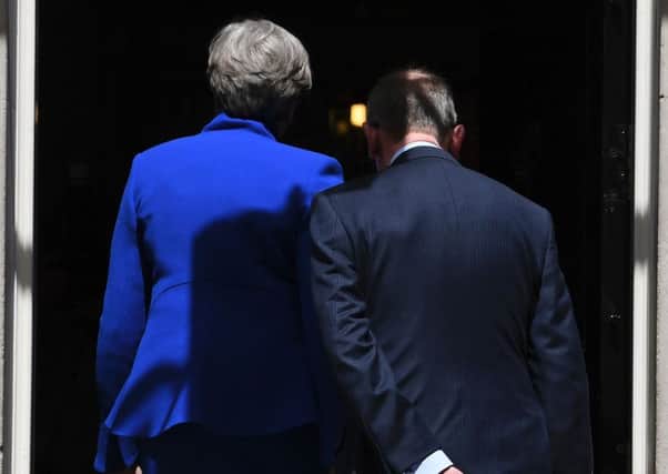 May and her husband, Philip, walk inside 10 Downing Street after the Prime Minister delivered a statement following the election. Picture: Justin Tallis/Getty
