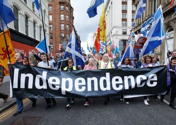 People taking part in the March for Independence wave Saltires as they process through Glasgow city on 3 June. Picture: Robert Perry/PA Wire