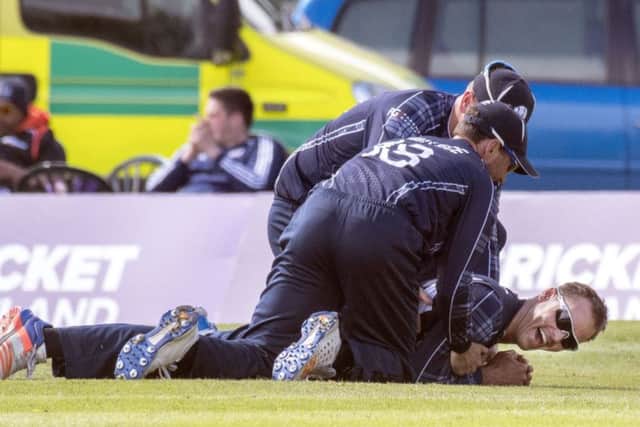 Scotland's Con de Lange is congratulated by team-mates asfter his superb diving catch to remove Namibia batsman Craig Williams. Picture: Donald Macleod