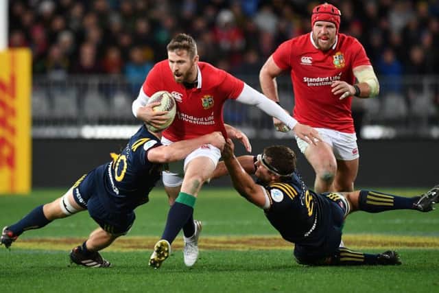 British and Irish Lions' Elliot Daly is tackled by Otago Highlanders' James Lentjes (L) and captain Luke Whitelock (2nd R). Picture: MARTY MELVILLE/AFP/Getty Images