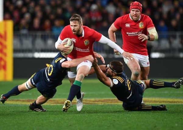 British and Irish Lions' Elliot Daly is tackled by Otago Highlanders' James Lentjes (L) and captain Luke Whitelock (2nd R). Picture: MARTY MELVILLE/AFP/Getty Images