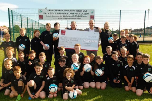Andrew Mickel, director of Mactaggart & Mickel, is greeted by Steven Dixon, chair of Dalkeith Thistle Community FC and their youths. Picture: Supplied
