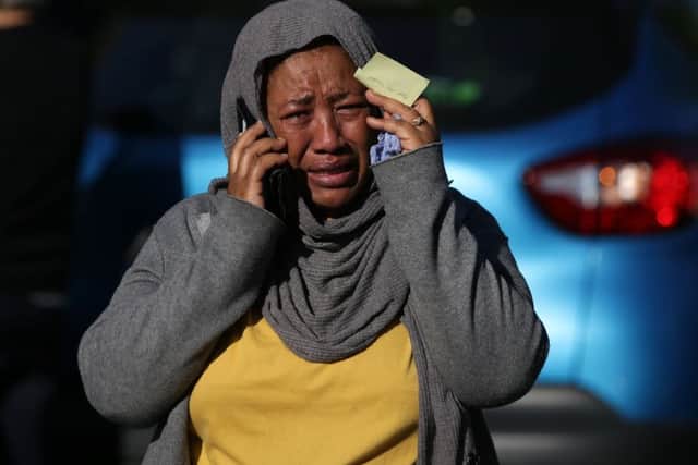 A woman cries as she tries to locate a missing relative suspected of being affected by the massive fire that engulfed Grenfell Tower. Picture: Getty Images