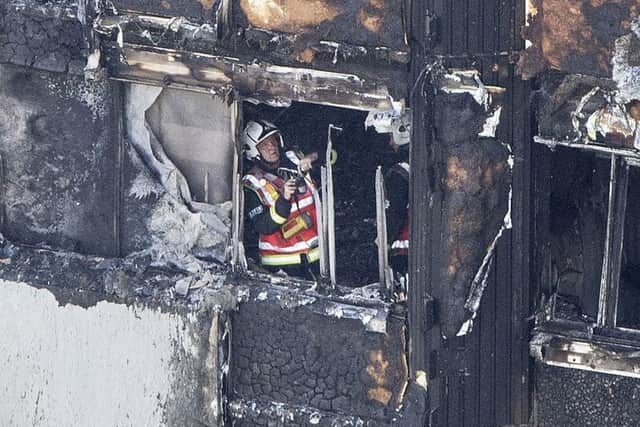 A firefighter investigates athe charred ruin of a floor in the west London tower. Picture: Rick Findler/PA Wire