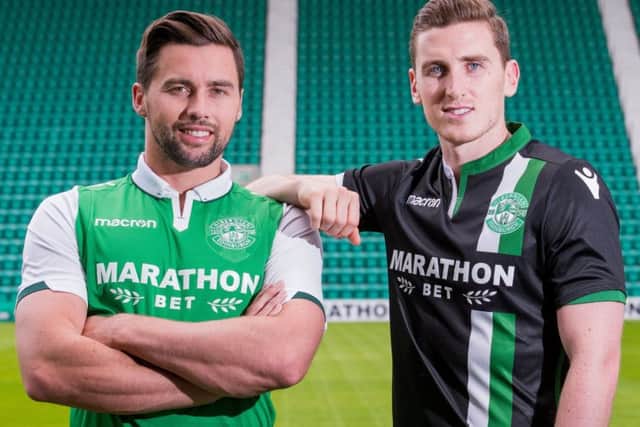 Defender Darren McGregor models the new Hibs home kit at Easter Road, while his fellow centre back Paul Hanlon sports the away version of the strip. Picture: Ian Georgeson