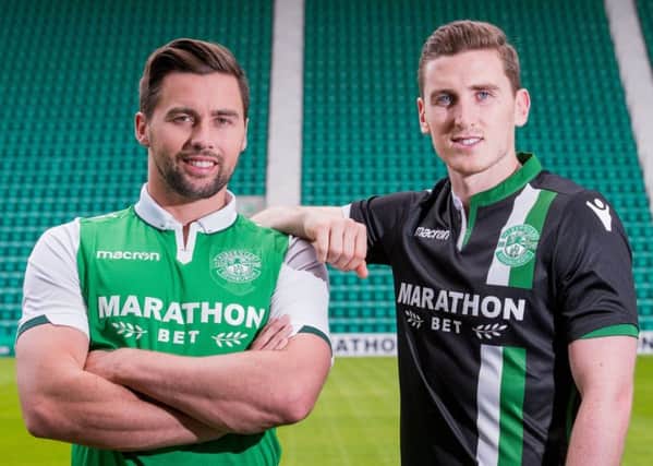 Defender Darren McGregor models the new Hibs home kit at Easter Road, while his fellow centre back Paul Hanlon sports the away version of the strip. Picture: Ian Georgeson
