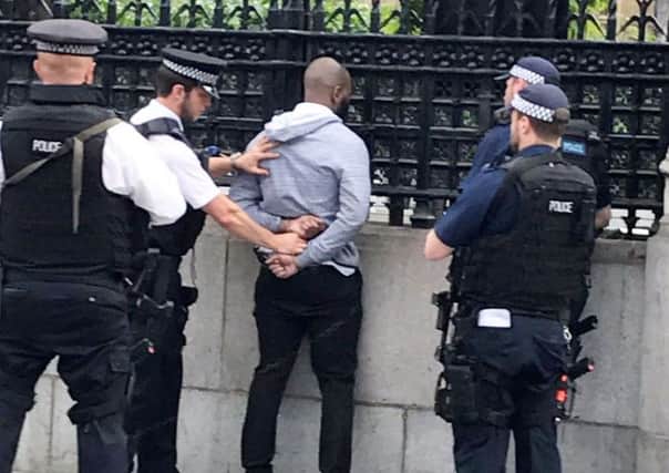 Police arrest a man outside the Houses of Parliament this morning.  Picture: SWNS
