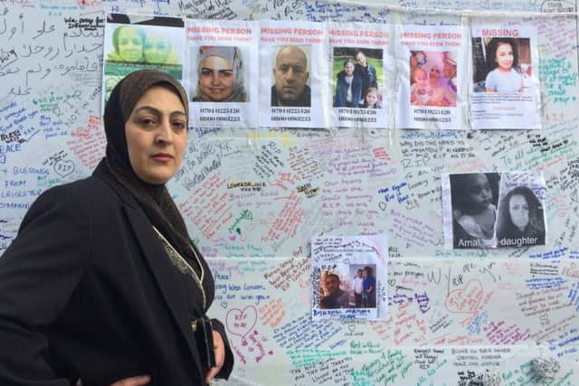 Sawsan Choucair at a tribute board near the Grenfell Tower fire where she has posted pictures of missing members of her family. Picture; SWNS