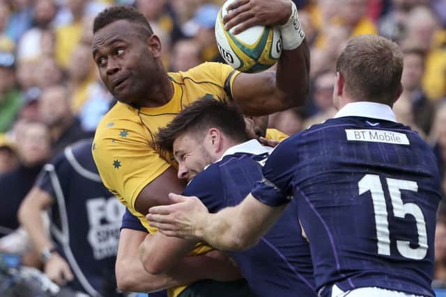 Australia's Eto Nabuli, left, looks to offload the ball while being tackled by Scotland's Greig Tonks, right, and Duncan Taylor during their rugby union test match in Sydney. Picture: AP Photo/Rick Rycroft