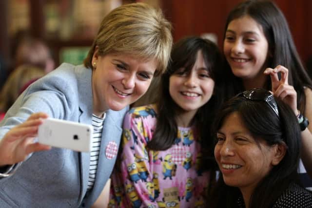 First Minister Nicola Sturgeon takes a photograph as she joins people at Glasgow Women's Library on Saturday.