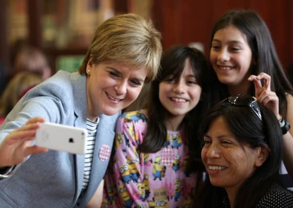 First Minister Nicola Sturgeon takes a photograph as she joins people at Glasgow Women's Library on Saturday.