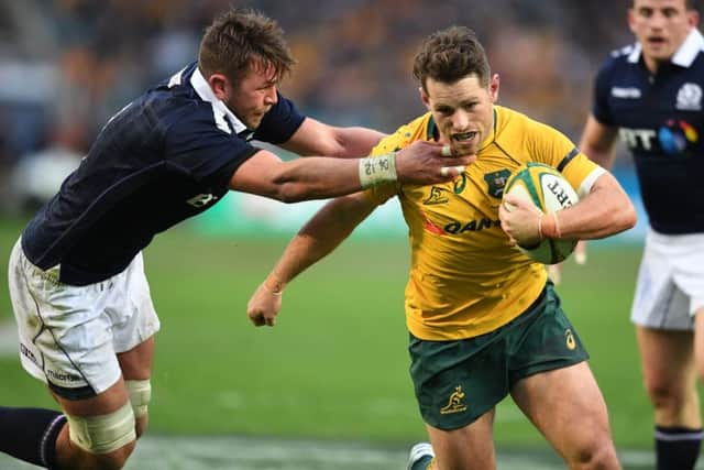 Australias  Bernard Foley attempts to escape from Ryan Wilson. Picture: David Gibson.