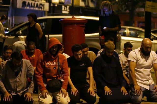 Muslims pray on a sidewalk in the Finsbury Park area of north London after a vehichle hit pedestrians. Picture: Getty Images