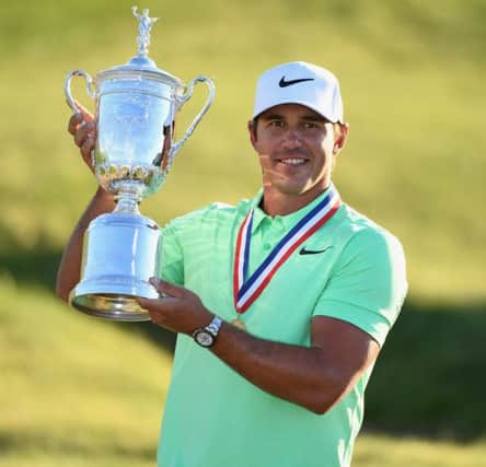 Brooks Koepka holds a loft the US Open Trophy after his victory at Erin Hills in Wisconsin. Picture: Getty Images