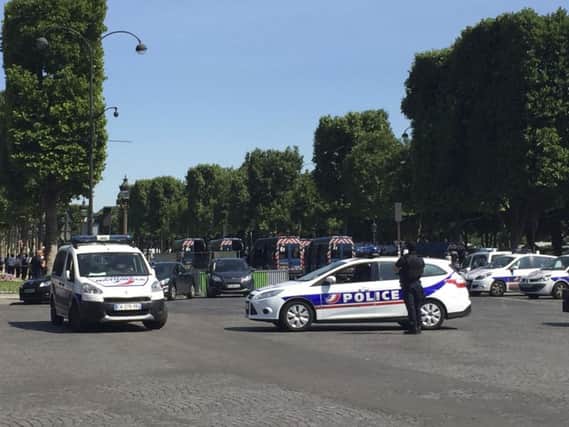 Police vehicles prevent the access to the Champs Elysees avenue in Paris on Monday. Picture: AP Photo/Bertrand Combaldieu