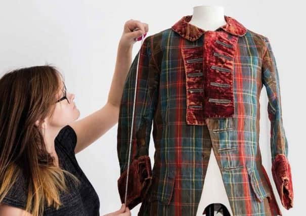 Danielle Connolly, a textiles conservator at the National Museum of Scotland, with the 18th Century frock coat believed to have been worn by Bonnie Prince Charlie. PIC: NMS.