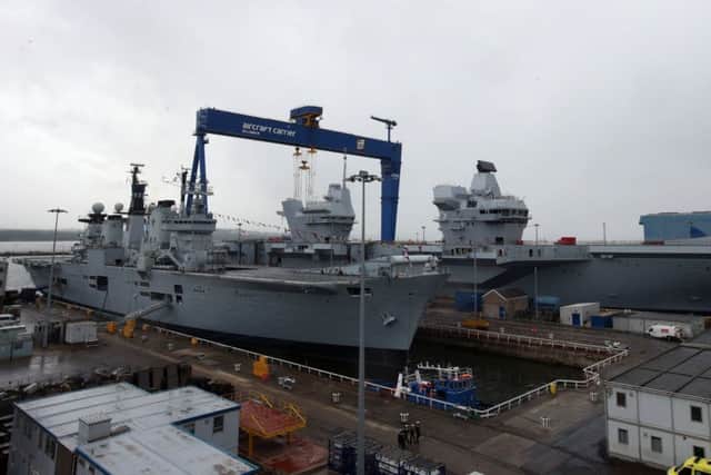 A 2014 view of HMS Illustrious in dry dock at Rosyth alongside HMS Queen Elizabeth (right) after the formal naming ceremony. Picture: Andrew Milligan/PA