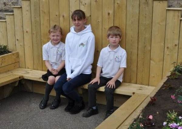 Kieran's mum is joined on the memorial bench by his classmates Carli Deacon and Mikey Maver. Picture: supplied