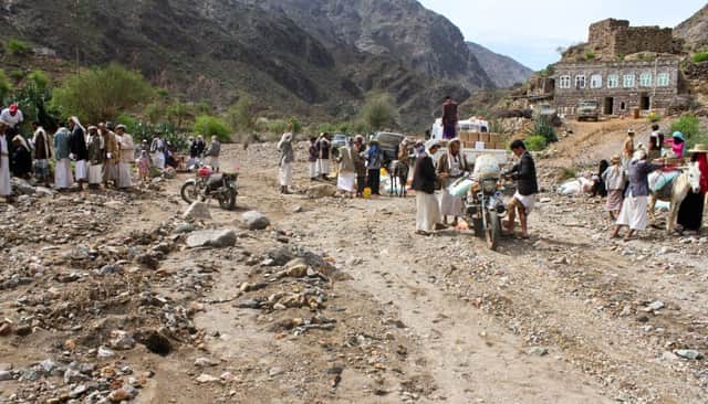 Yemenis gather to carry home food rations provided by Mercy Corps