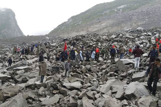 Emergency personnel and locals work at the site of a landslide in Xinmo village. Picture: Chinatopix/AP