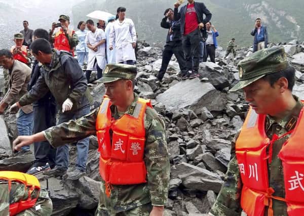 Dozens of people are feared buried by the landslide that crashed into their homes in southwestern China. Picture: Chinatopix/AP