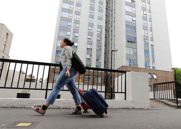 A woman with suitcases leaves Taplow Tower residential block on the Chalcots Estate in north London. Picture: Getty