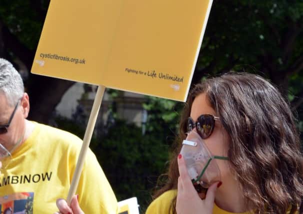Protesters wearing oxygen masks  gather outside Holyrood to call for the life-saving cystic fibrosis drug, Orkambi, to be made available on the NHS in Scotland. Picture: Jon Savage
