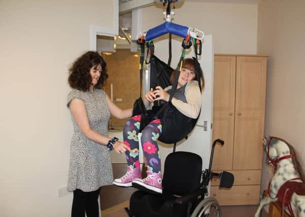 Alison and Anna use the hoist at Rebecca Cottage, one of the many specialist items of equipment available at the respite home which has been given a cash boost. Picture: Supplied