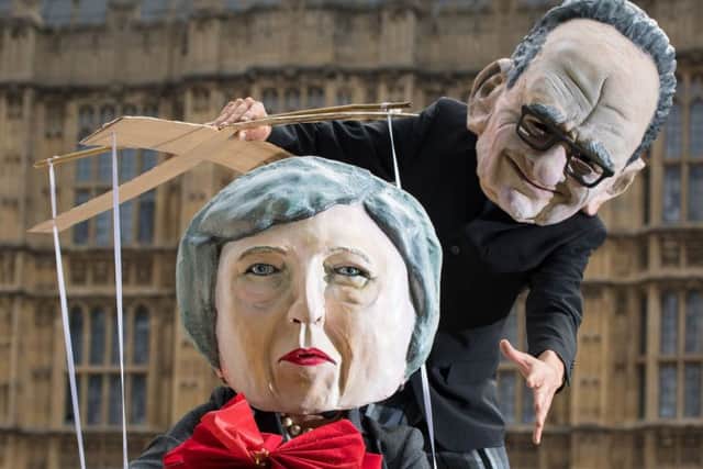 Campaigners dressed as Prime Minister Theresa May and Rupert Murdoch outside the Houses of Parliament. Picture: Dominic Lipinski/PA Wire