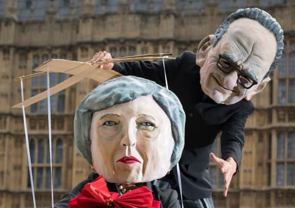 Campaigners dressed as Prime Minister Theresa May and Rupert Murdoch outside the Houses of Parliament. Picture: Dominic Lipinski/PA Wire