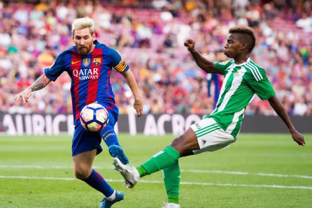 Charly Musonda (right) attempts to evade the attentions of Lionel Messi in a match between Real Betis and Barcelona. Picture: Getty Images