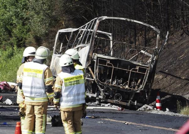 Fire fighters stand beside a burnt-out coach on the motorway A9 near Muenchberg, southeastern Germany, Picture; AP