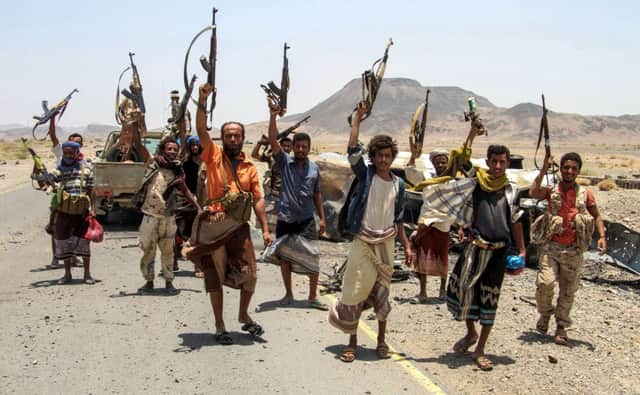 Yemeni fighters loyal to the Saudi-backed Yemeni president pose for a picture raising their machine guns on April 15, 2017, on the road leading to Khaled Ibn Al-Walid base, 30 kilometres (20 miles) east of the government-held Red Sea port town of Mokha which pro-government forces retook in February.
The Khaled Ibn Al-Walid camp, one of the biggest in Yemen, sits on a key road linking Mokha to the Huthi-controlled port city of Hodeida and third city Taez, which is under rebel siege.
Loyalist forces launched a major offensive on January 7 to retake Yemen's 450-kilometre (280-mile) coastline as far as Midi, close to the Saudi border. / AFP PHOTO / SALEH AL-OBEIDI        (Photo credit should read SALEH AL-OBEIDI/AFP/Getty Images)