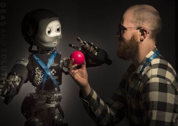 A Phd student at the Heriot-Watt Edinburgh Centre for Robotoics plays with Nikita, a humanoid robot in development for more than ten years. Robots will be more and more important in the workplace of the future. Picture: Andrew O'Brien