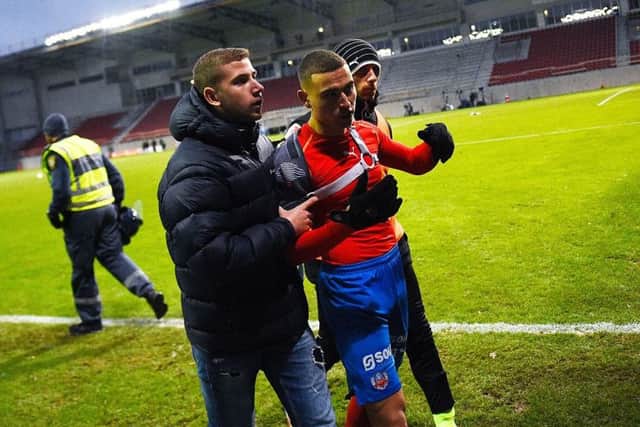 Jordan Larsson leaves the pitch after being attacked by hooligans following Helsingborg's relegated. Picture: AFP