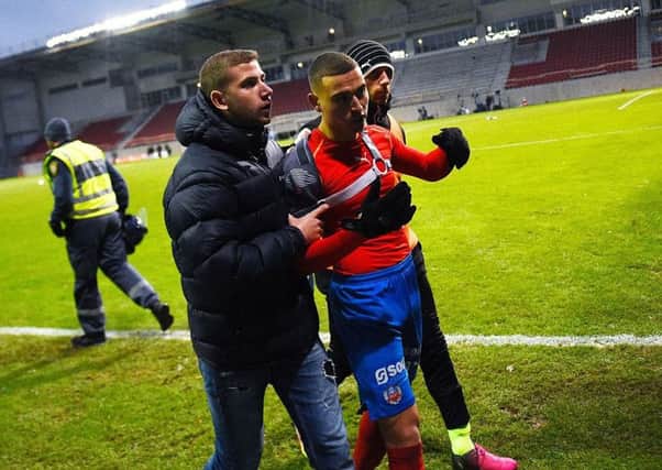 Jordan Larsson leaves the pitch after being attacked by hooligans following Helsingborg's relegated. Picture: AFP
