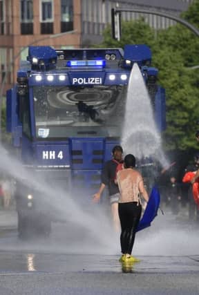 HAMBURG, GERMANY - JULY 07: Police use water cannons as protesters gather to participate in an anti-G20 march on July 7, 2017 in Hamburg, Germany. Authorities are braced for large-scale and disruptive protests as Leaders of the G20 group of nations arrive in Hamburg for the July 7-8 G20 summit. (Photo by Alexander Koerner/Getty Images)