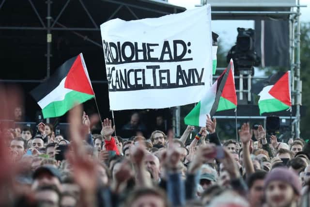 Protesters wave Palestinian flags as Radiohead perform on the main stage at TRNSMT festival in Glasgow. Picture: Andrew Milligan/PA Wire