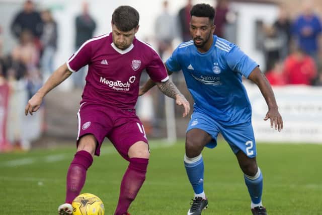 Shay Logan, wearing Aberdeen's new blue away kit, in action against
Arbroath's Bobby Linn during a pre-season friendly. Picture: Bruce White/SNS