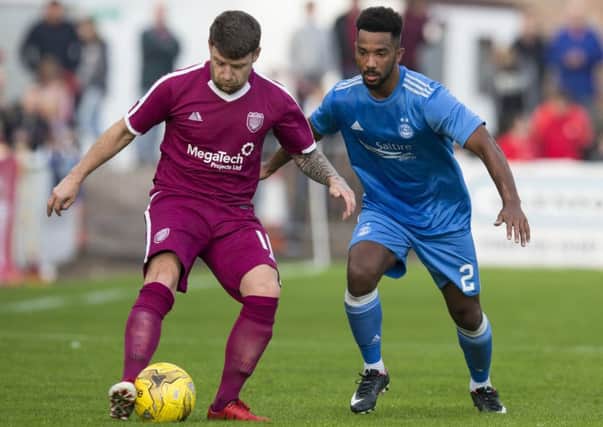 Shay Logan, wearing Aberdeen's new blue away kit, in action against
 Arbroath's Bobby Linn during a pre-season friendly. Picture: Bruce White/SNS
