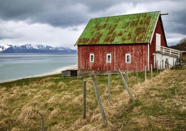 Barn, house by the fjord, mountains with snowy peaks behind, Kvaloya, Troms, Norway. Picture: Nordreisender/imageBROKER/REX/Shutterstock